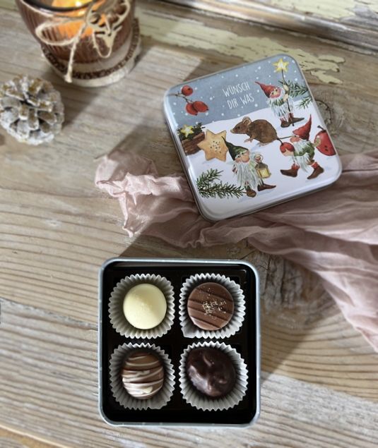 Stimmungsvoll verpackte Weihnachtsgeschenke vor leuchtendem Christbaum