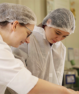 Eine Ausbilderin in der Produktion mit einem Auszubildenden